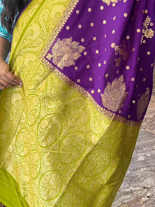 Purple and green saree with intricate patterns on a stone surface