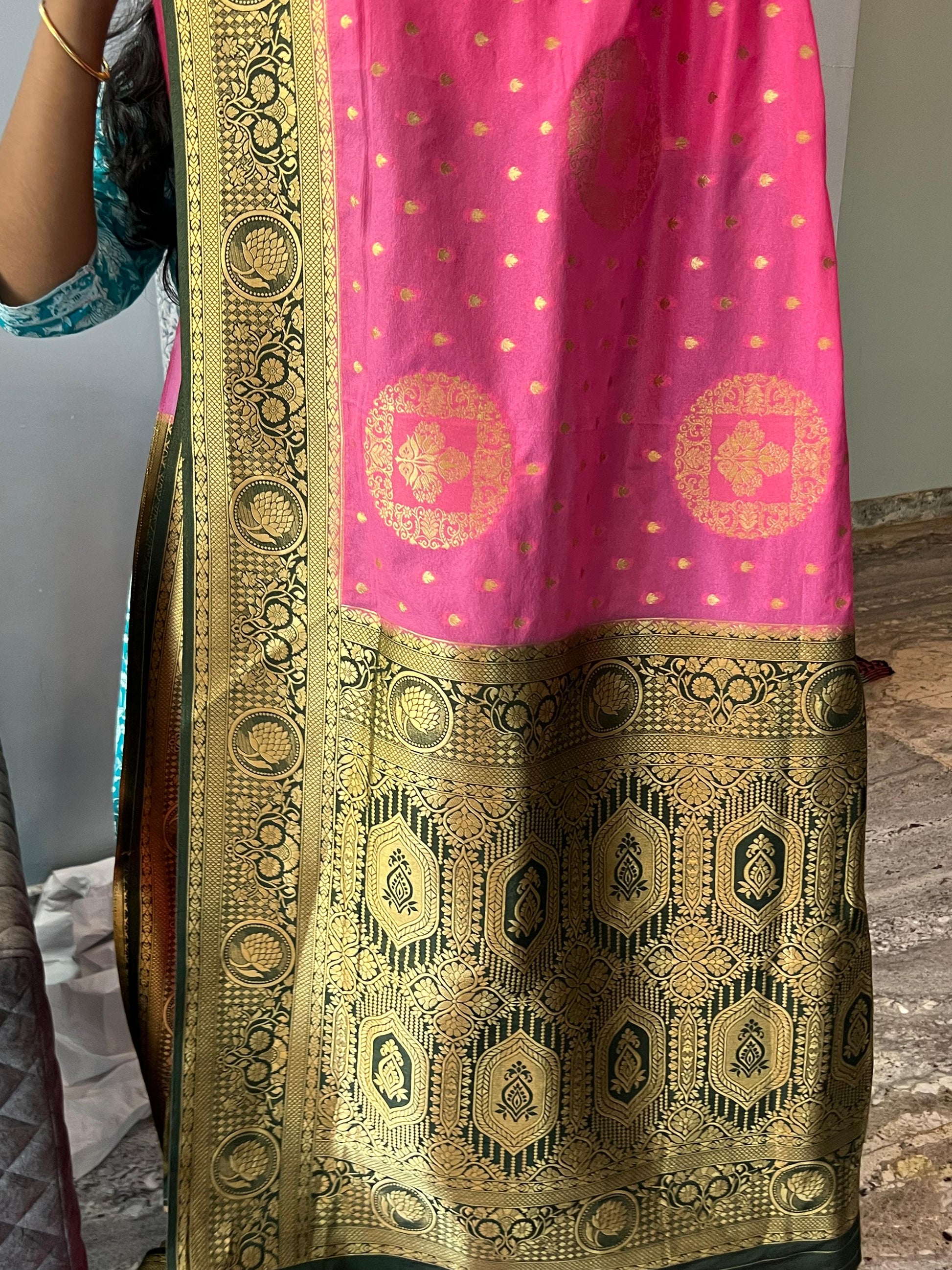 Traditional saree with pink and gold pattern on a neutral background