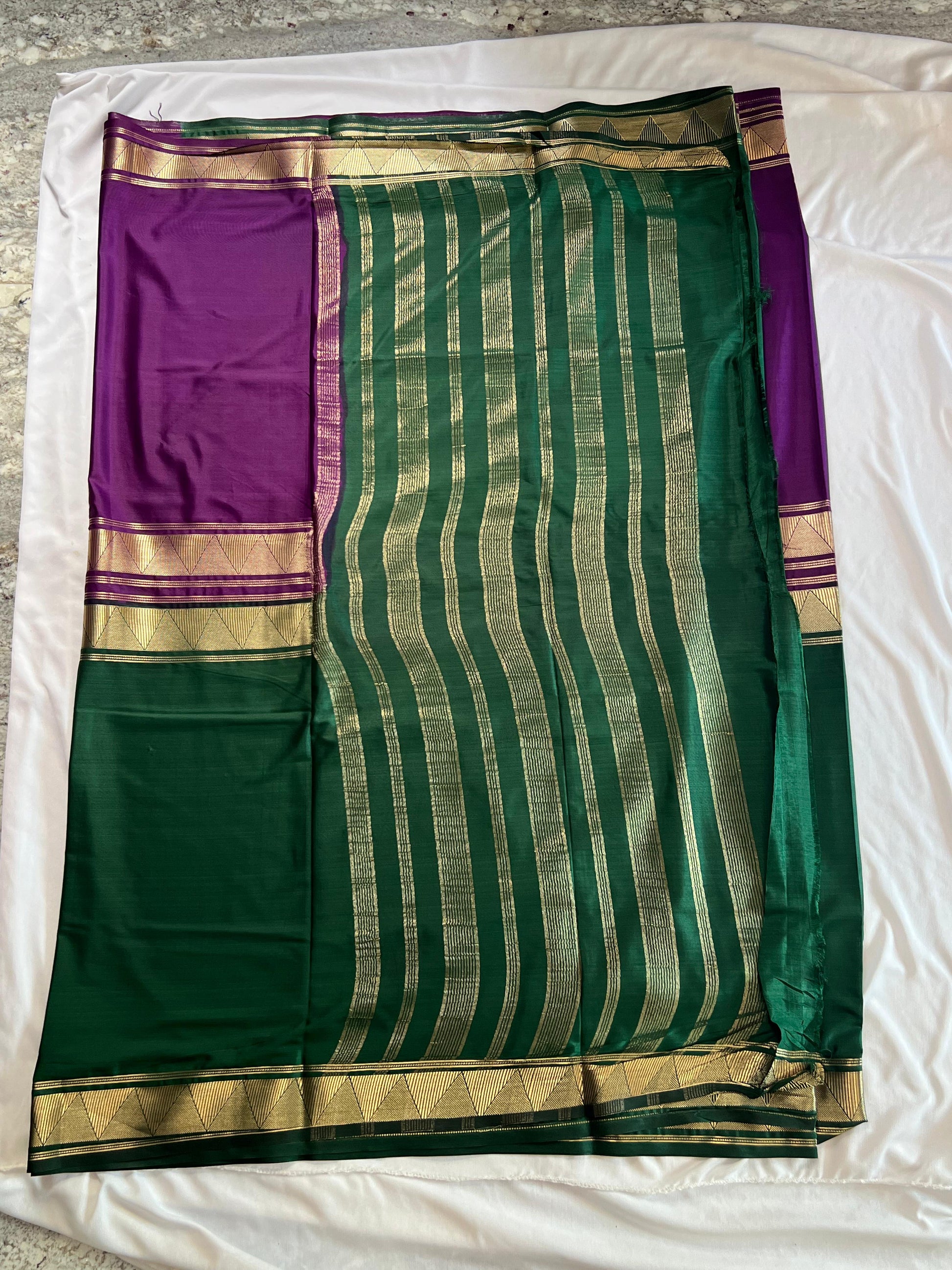 Green and purple saree with gold stripes on a white background
