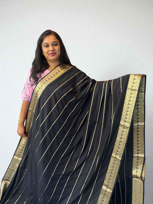 Black semi crepe saree with gold striped design and Mysore-style drape